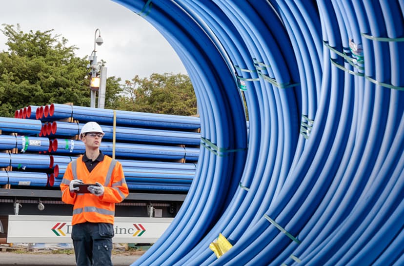 A water company worker inspecting a construction site using a tablet